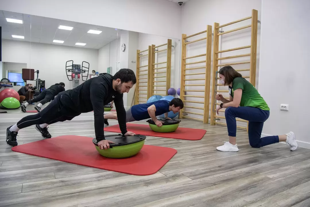 Rehabilitation therapist provides exercise therapy classes with patients suffering from lower back pain